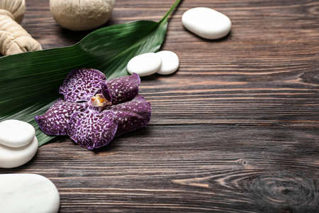 Spa composition with stones and orchid flower on wooden backgroundの写真素材