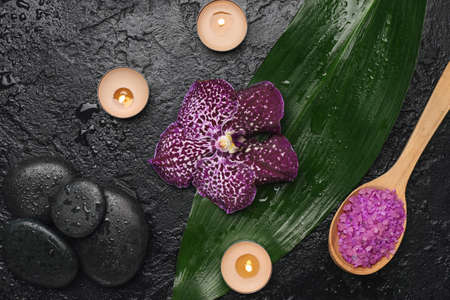 Spa composition with aroma candles, sea salt and stones on dark backgroundの写真素材