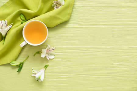 Cup with tasty floral tea on color wooden backgroundの写真素材