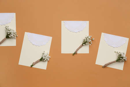 Beautiful gypsophila boutonnieres and wedding invitations on color backgroundの写真素材
