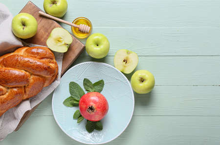 Honey with fruits and challah on color wooden background. Rosh hashanah (Jewish New Year)...