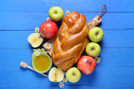 Honey with fruits and challah on color wooden background. Rosh hashanah (Jewish New Year) celebrationの写真素材