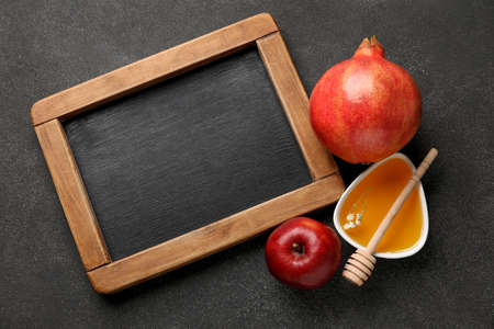 Symbols of Rosh hashanah (Jewish New Year) and empty chalkboard on dark backgroundの写真素材
