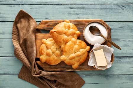 Board with bread of the dead and ingredients on color wooden background. Celebration of Mexico's Day...