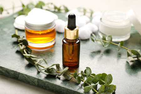 Board with cosmetic products and eucalyptus branches, closeupの写真素材