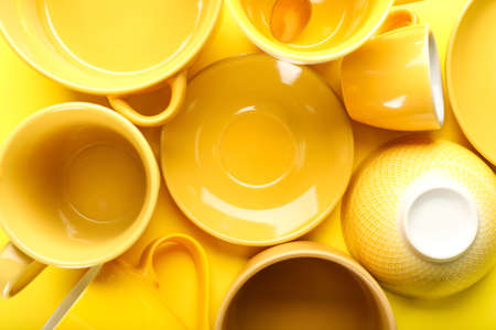 Set of clean tableware on yellow backgroundの写真素材