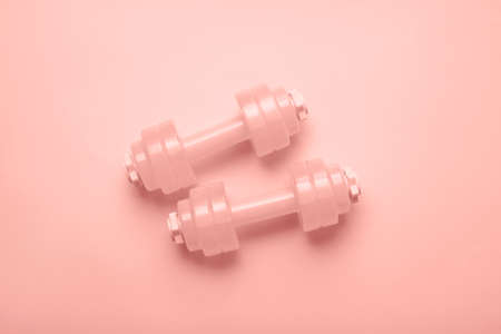 Pair of dumbbells on pink background