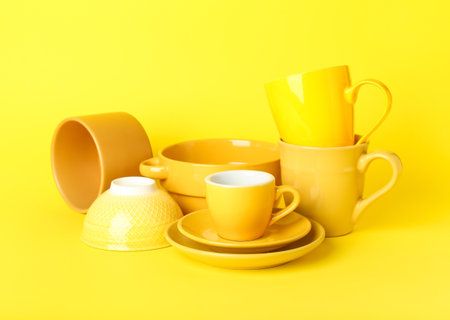 Set of clean tableware on yellow backgroundの写真素材