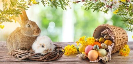 Beautiful greeting card with Easter eggs and cute bunnies in garden