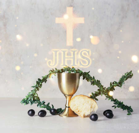 Chalice of wine with bread and fish made of branches on light background. Holy Communion conceptの写真素材