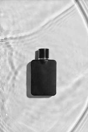 Bottle of perfume in water on light background, top viewの写真素材