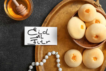 Tray with tasty Arabic cookies, honey and greeting card for for Eid al-Fitr (Feast of Breaking the...