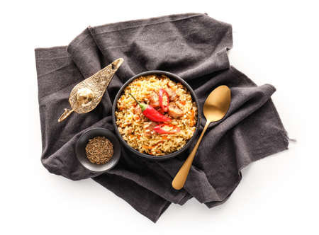 Bowl of traditional pilaf and Aladdin lamp on white backgroundの写真素材