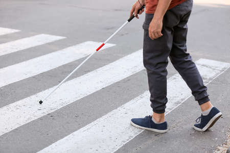 Blind senior man crossing road in cityの写真素材