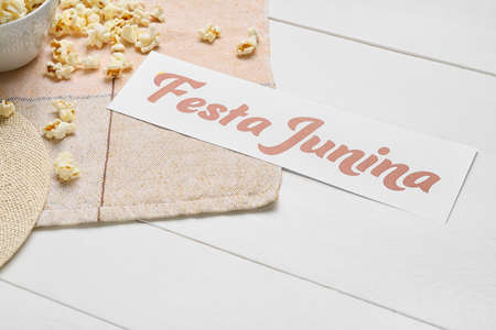 Popcorn and paper with text FESTA JUNINA (June Festival) on wooden background