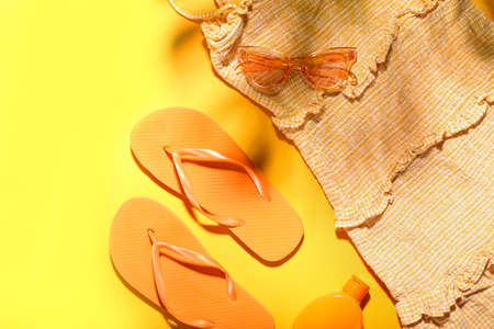 Set of beach accessories and dress on color backgroundの写真素材