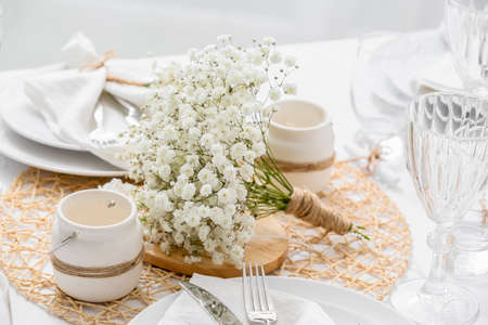 Beautiful table setting with gypsophila flowers in restaurantの写真素材