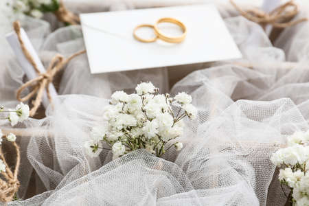 Box with beautiful gypsophila boutonnieres and wedding rings, closeup