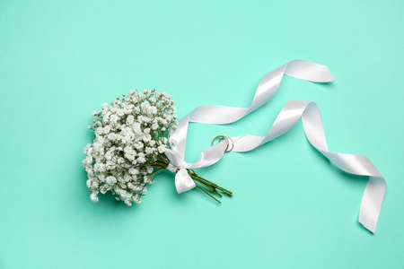 Beautiful wedding bouquet with gypsophila flowers on color background