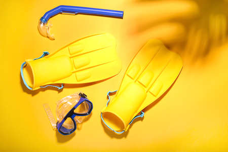 Flippers, snorkeling mask and tube on color backgroundの写真素材