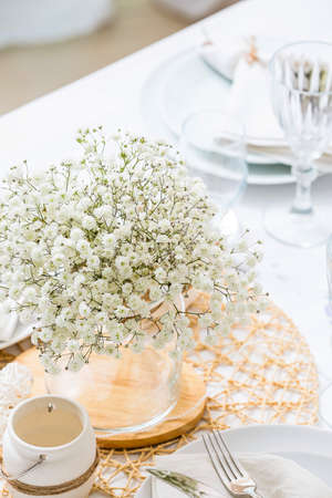 Vase with beautiful white gypsophila flowers on tableの写真素材