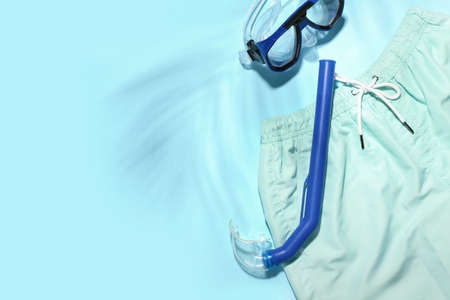 Male swimming trunks, snorkeling mask and tube color background