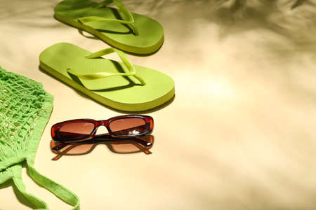 Set of beach accessories on color background