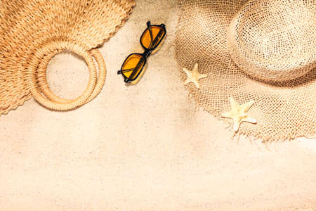 Stylish hat, sunglasses and bag on sandの写真素材
