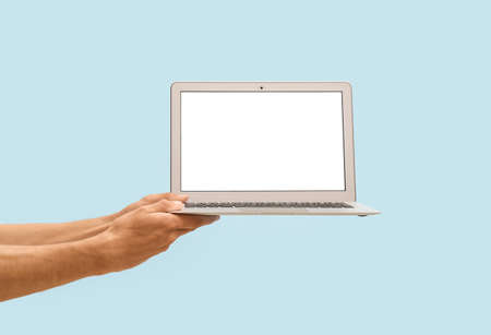 Male hands with modern laptop on color background