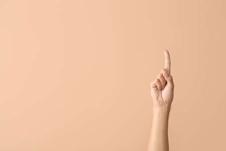 Young male hand showing something on color background