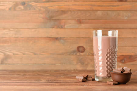 Glass of delicious chocolate milk on wooden backgroundの写真素材