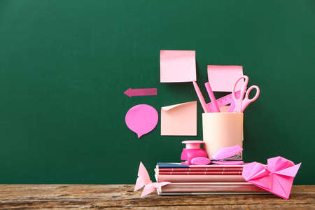 Chalkboard with sticker notes, origami and stationery in classroom