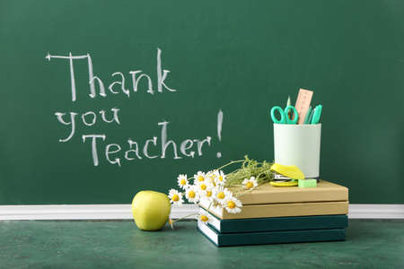 Books with flowers, apple, stationery and text THANK YOU TEACHER on color backgroundの写真素材