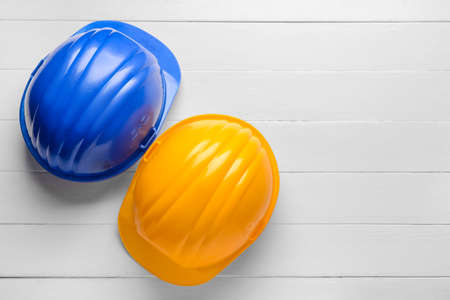 Plastic hardhats on white wooden backgroundの写真素材