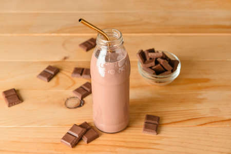 Bottle of delicious chocolate milk on wooden backgroundの写真素材
