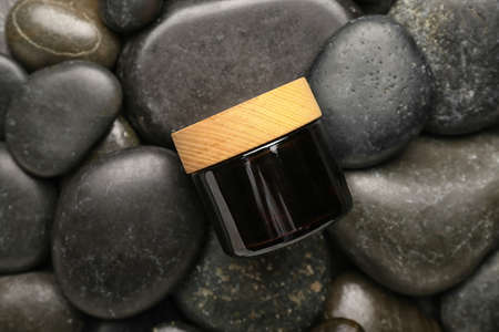 Jar of cosmetic product on spa stones background