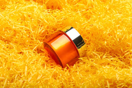 Cosmetic jar with cream on color confetti background