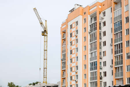 View of modern bright building and construction crane in city