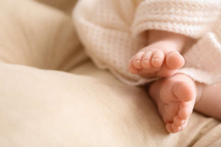 Adorable baby legs on bed, closeup