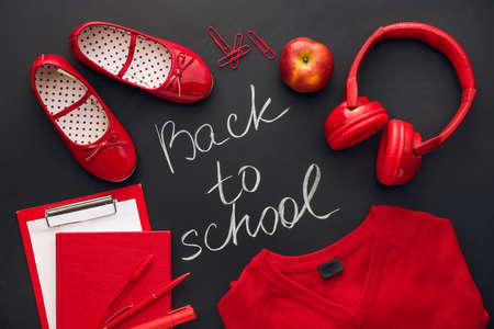 Text BACK TO SCHOOL, uniform, stationery and headphones on dark background, closeupの写真素材