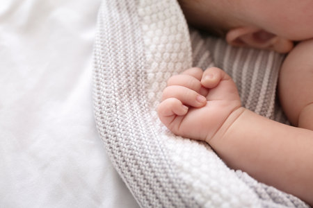 Adorable baby arm on bed, closeup