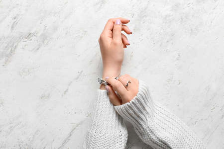 Woman with beautiful manicure and stylish jewelry on light background