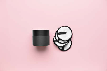 Reusable cotton pads and box on color background
