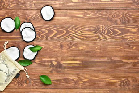 Reusable cotton pads and bag on wooden background