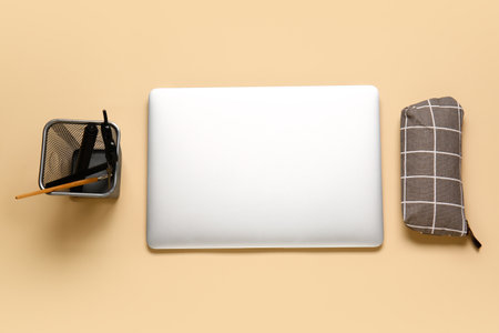 Stylish pencil case, laptop and stationery on color backgroundの写真素材