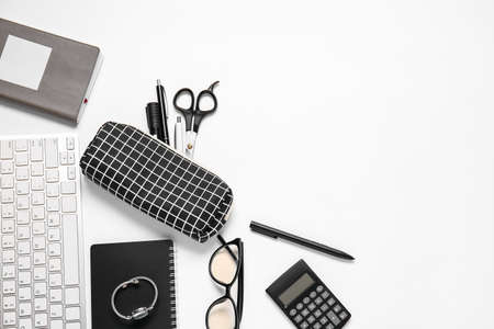 Pencil case, keyboard, accessories and stationery on white background