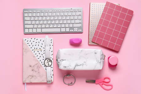 Pencil case, female accessories, keyboard and stationery on color background