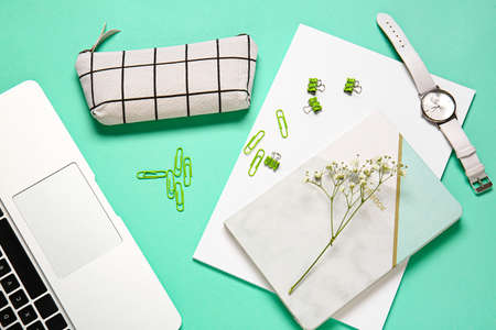 Stylish pencil case, wrist watch and stationery on color background, closeup