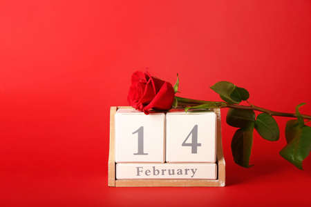 Calendar with date of February 14 and rose on color background