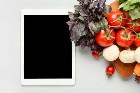 Tablet computer with healthy products on white backgroundの写真素材